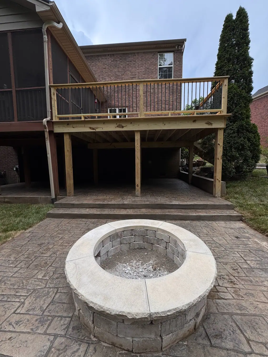 Round stone fire pit on a stamped concrete patio
