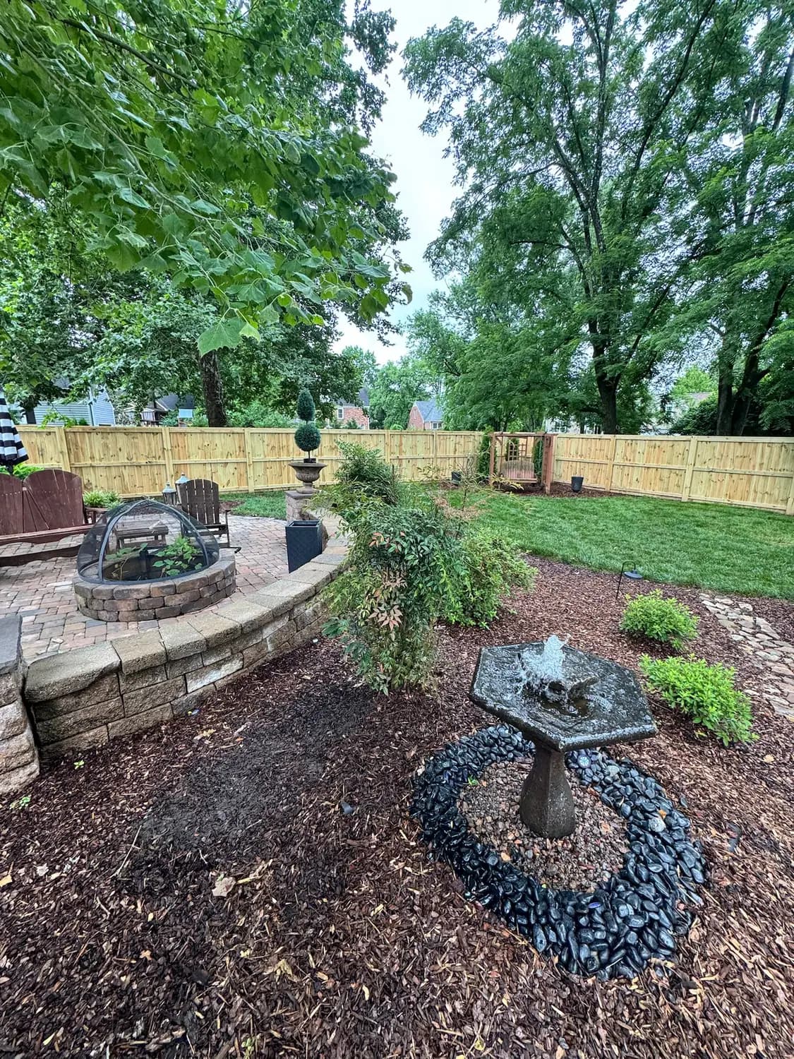 Paver fire pit area with a raised seat wall and planting beds