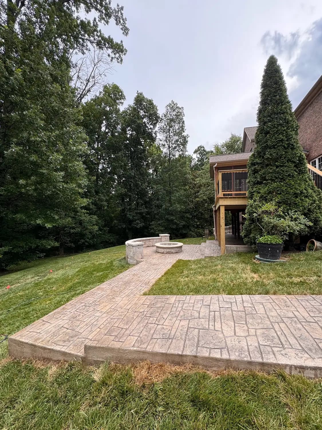 Curved stamped concrete patio with a built-in fire pit