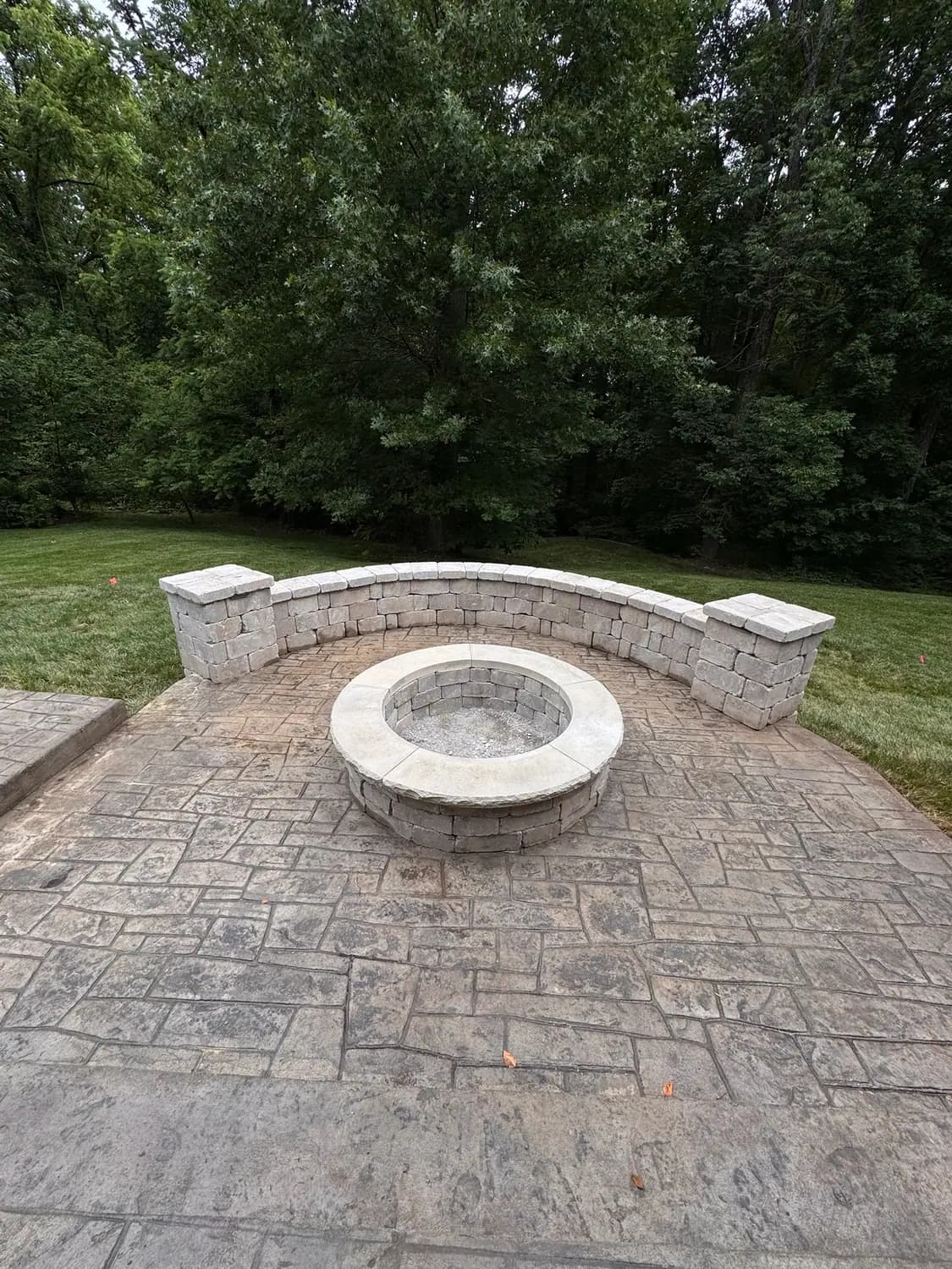 Patio fire pit framed by a stone seat wall