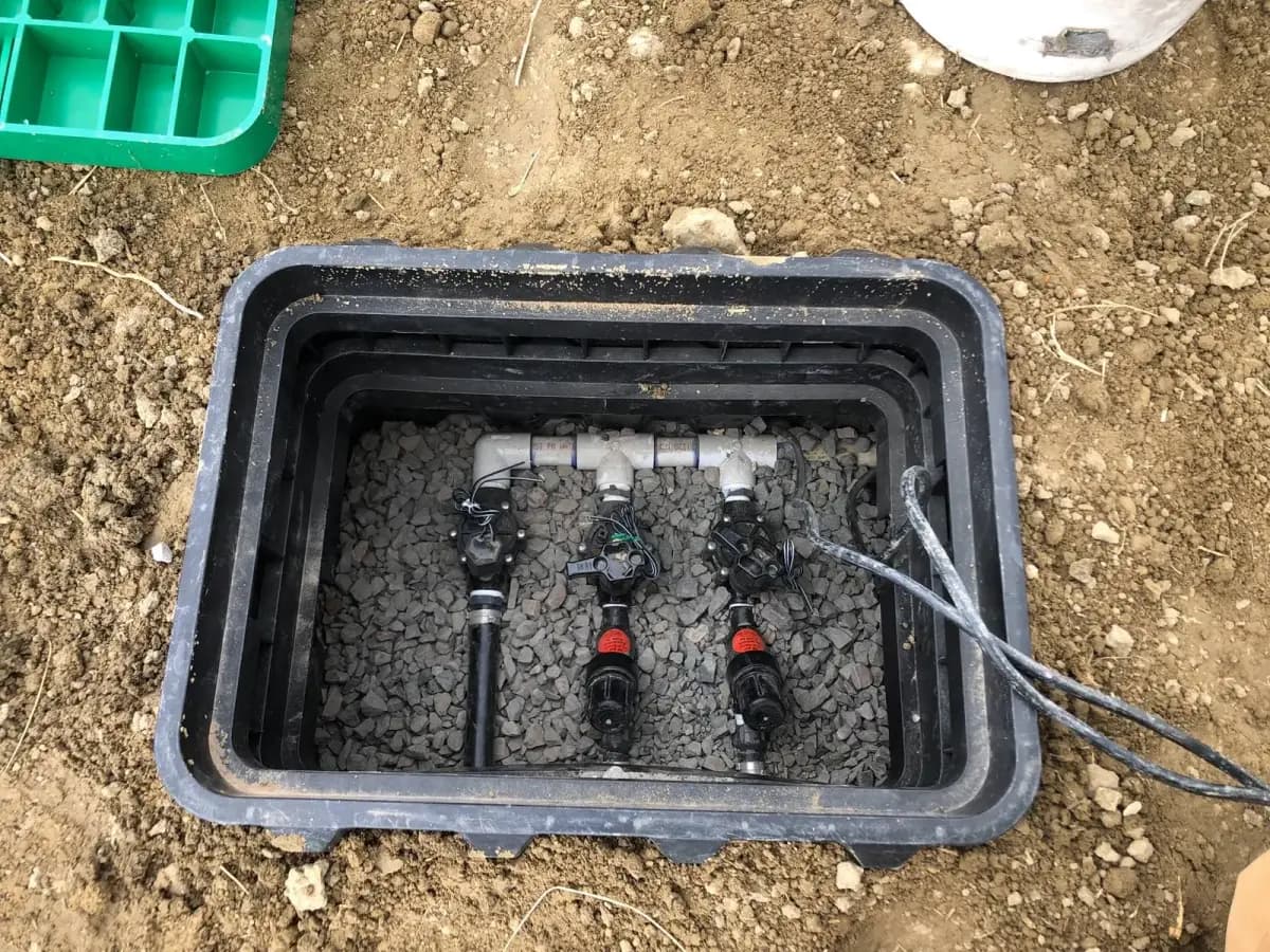 New irrigation valve manifold set in a gravel-lined box