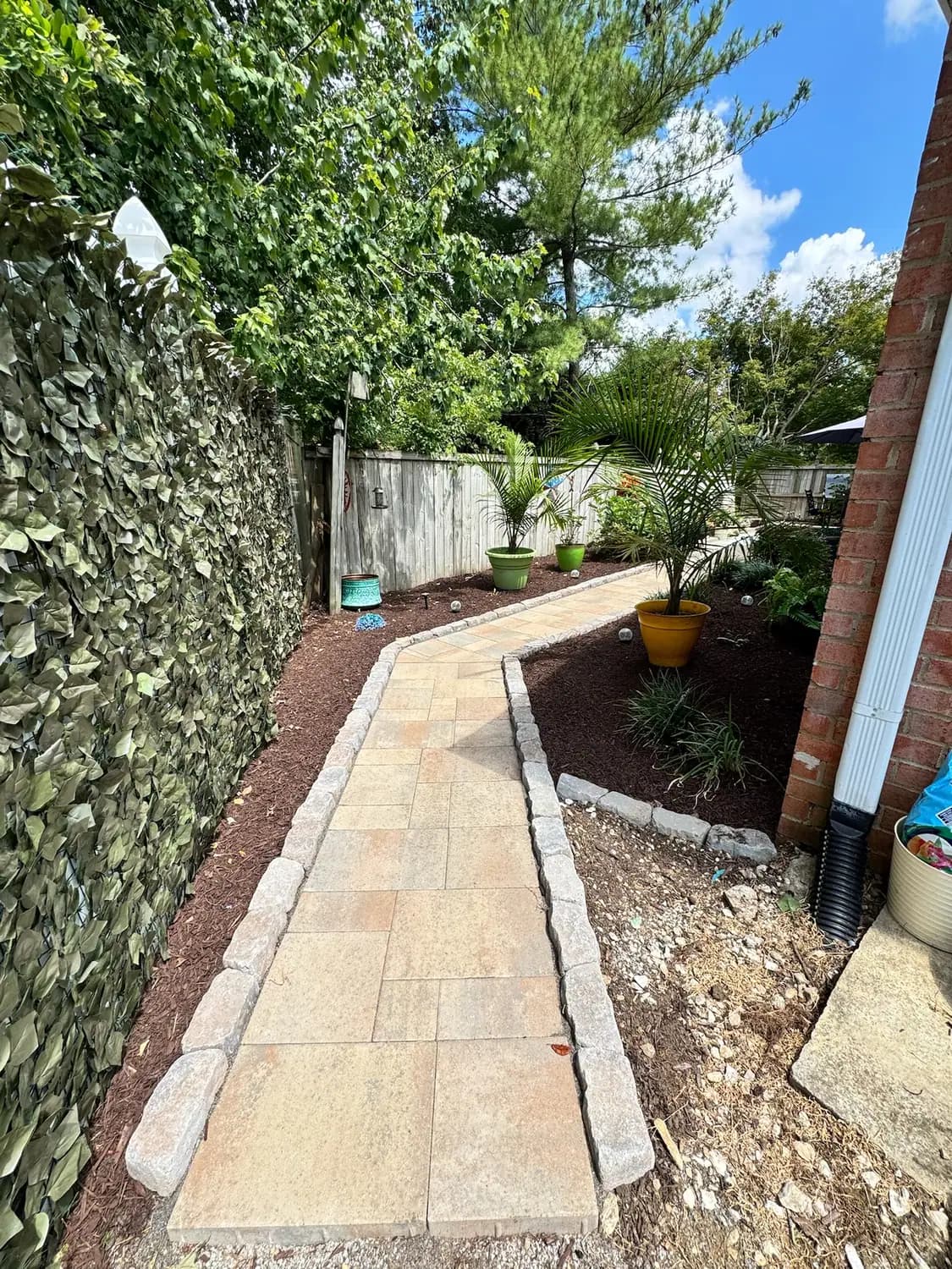 Paver walkway with cobble edging and container plantings