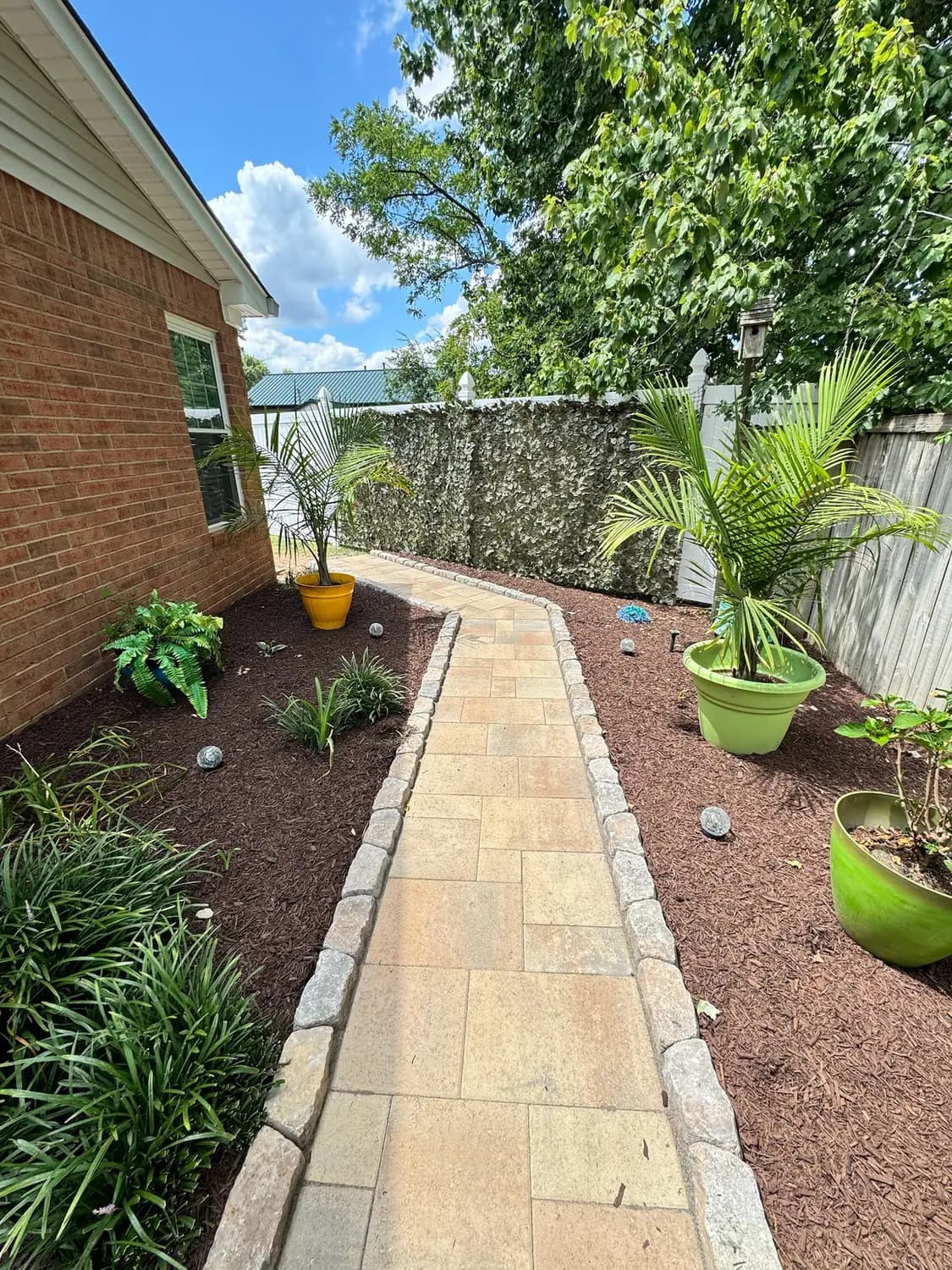 Side yard paver walkway with container plantings