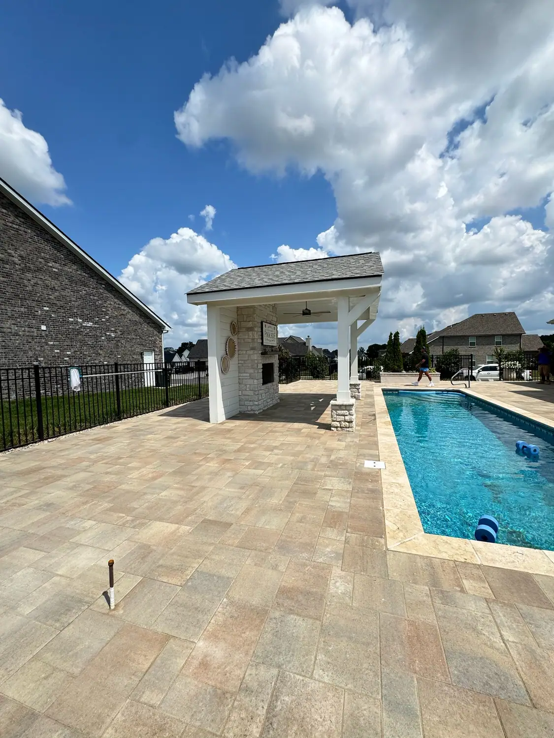 Pool with paver decking and a stone-column pavilion