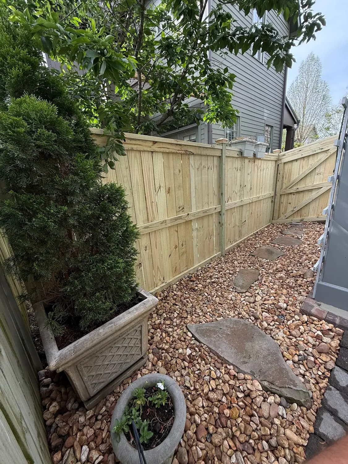 Side yard river rock drainage channel with a stone path