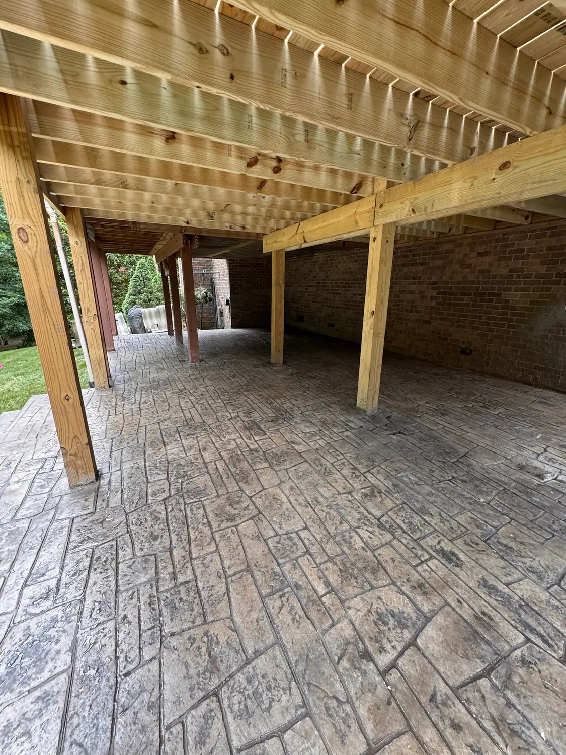 Stamped concrete patio beneath a raised deck