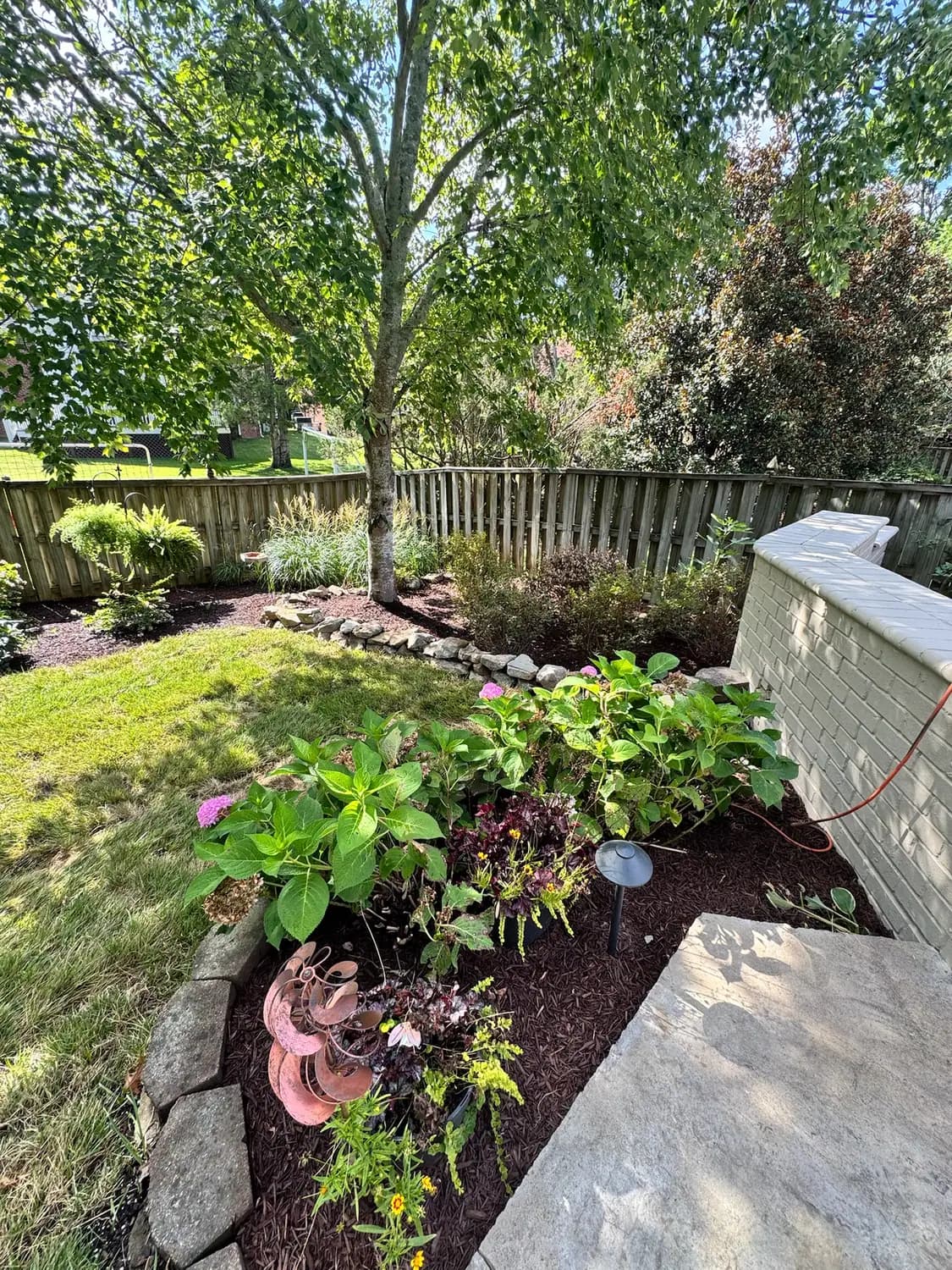 Stone-edged perennial bed with layered plantings