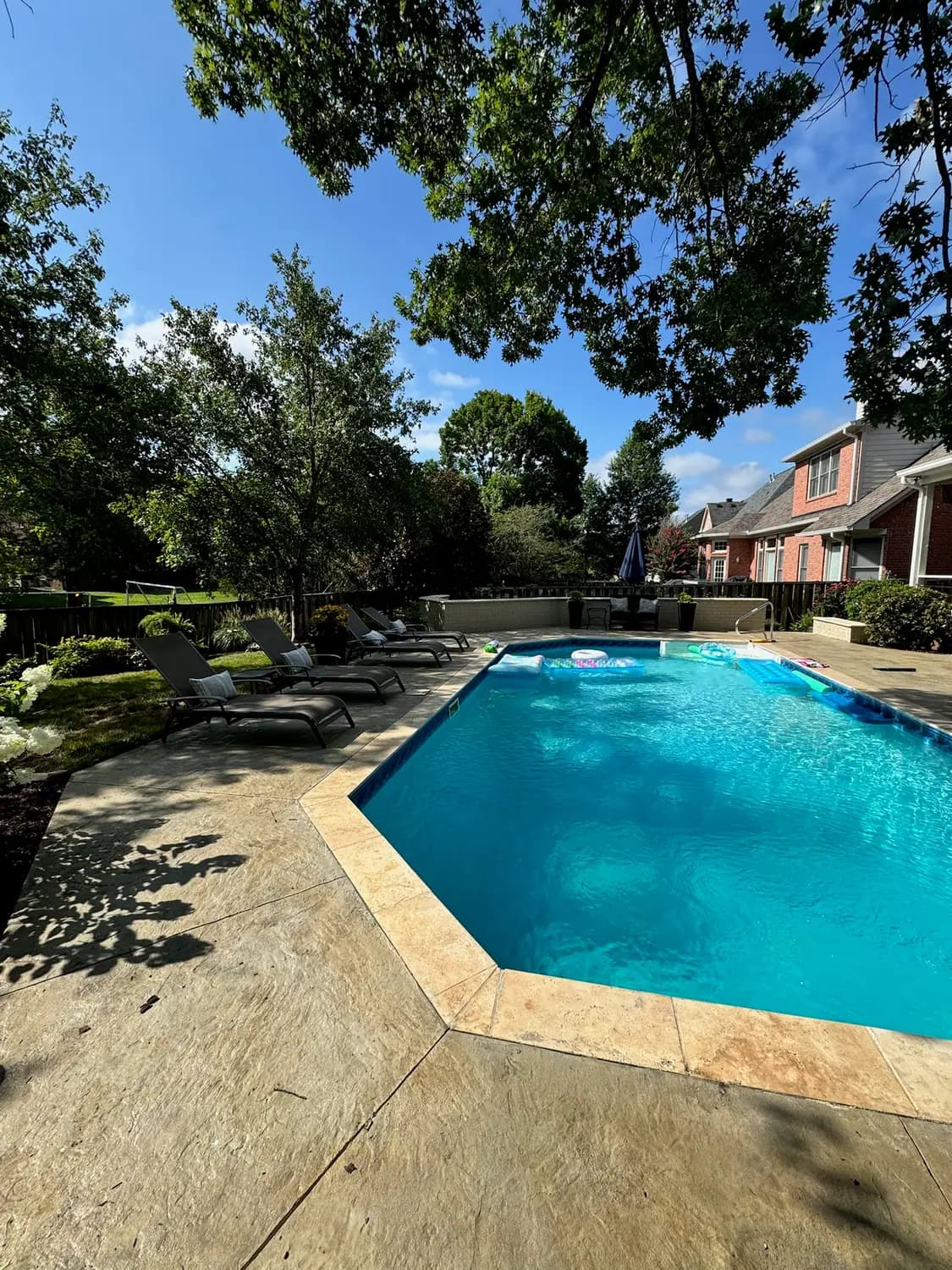Swimming pool with a stamped concrete pool deck